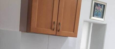 Una cocina pequeña con armarios de madera, un lavamanos y una encimera.
