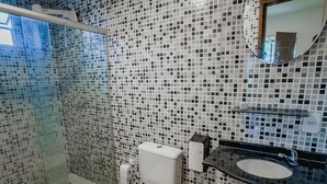 Et badeværelse med toilet, vask og bruser.
