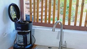 A compact kitchen with a wooden countertop, a coffee maker, and a stainless steel sink. - Cabin with beautiful view of Coatepeque Lake, Santa Ana to relax, AC, hot water+ (Santa Ana)