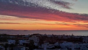 Un pueblo costero al atardecer con edificios y vista al mar.