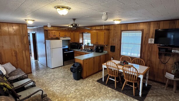 Un espacio habitable compacto con kitchenette, comedor y zona de estar.