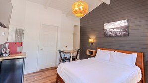 A bedroom with a bed, a desk with a chair, a small table, and a picture on the wall. - Tahoe Mountain Inn #13 (SOUTH LAKE TAHOE)