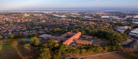 An aerial view of a residential area with a large building complex, surrounded by trees and open spaces.