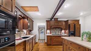 A kitchen with wooden cabinets, a microwave, and a refrigerator.