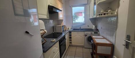 Een koelkast, kookgerei, borden en bestek