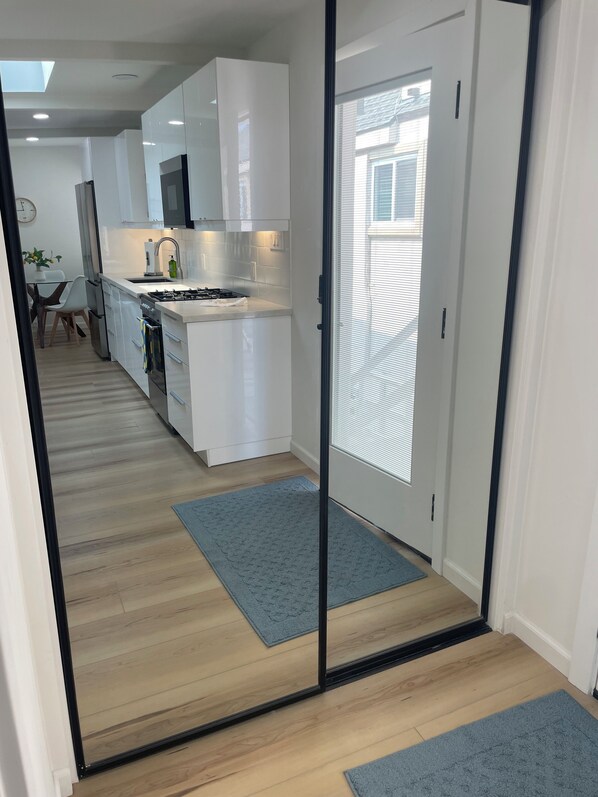 A modern kitchen with white cabinets, a gas stove, and a dining area with a table and chairs.