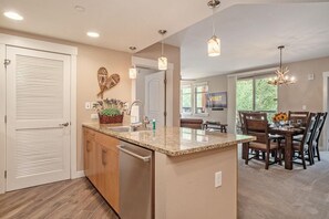 A modern kitchen with a granite countertop, wooden cabinets, and a built-in dishwasher.