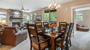 A dining area with a fireplace, a chandelier, and a view of the outdoors.