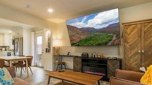 Una sala de estar moderna con un televisor de pantalla plana grande, una chimenea y una zona de estar acogedora.