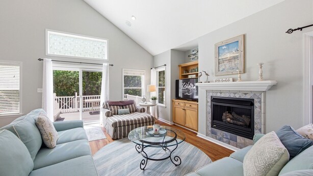 A spacious living room with a fireplace, a television, and a balcony. - Coast to Coast:Dog Friendly, Private Pool, Hot Tub, Community Amenities (Corolla)