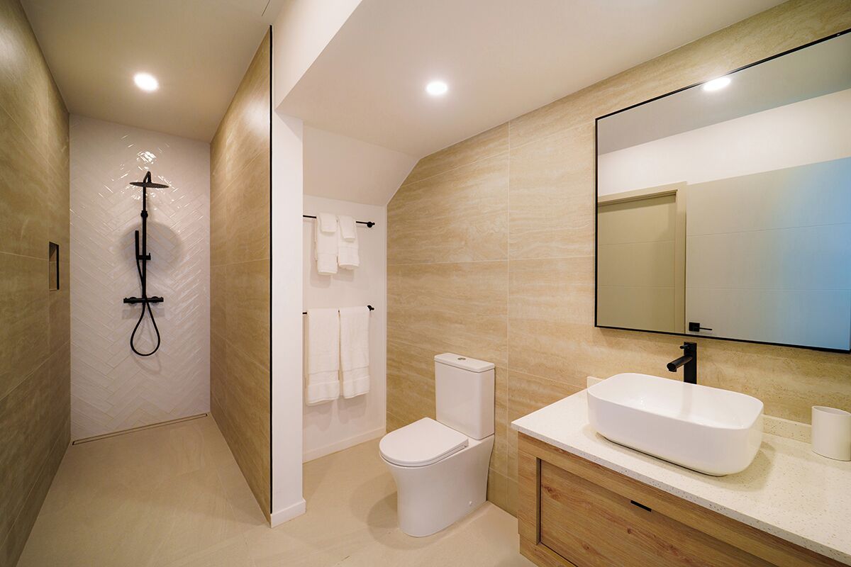 Une salle de bain moderne équipée d’une douche, de toilettes et d’un lavabo.