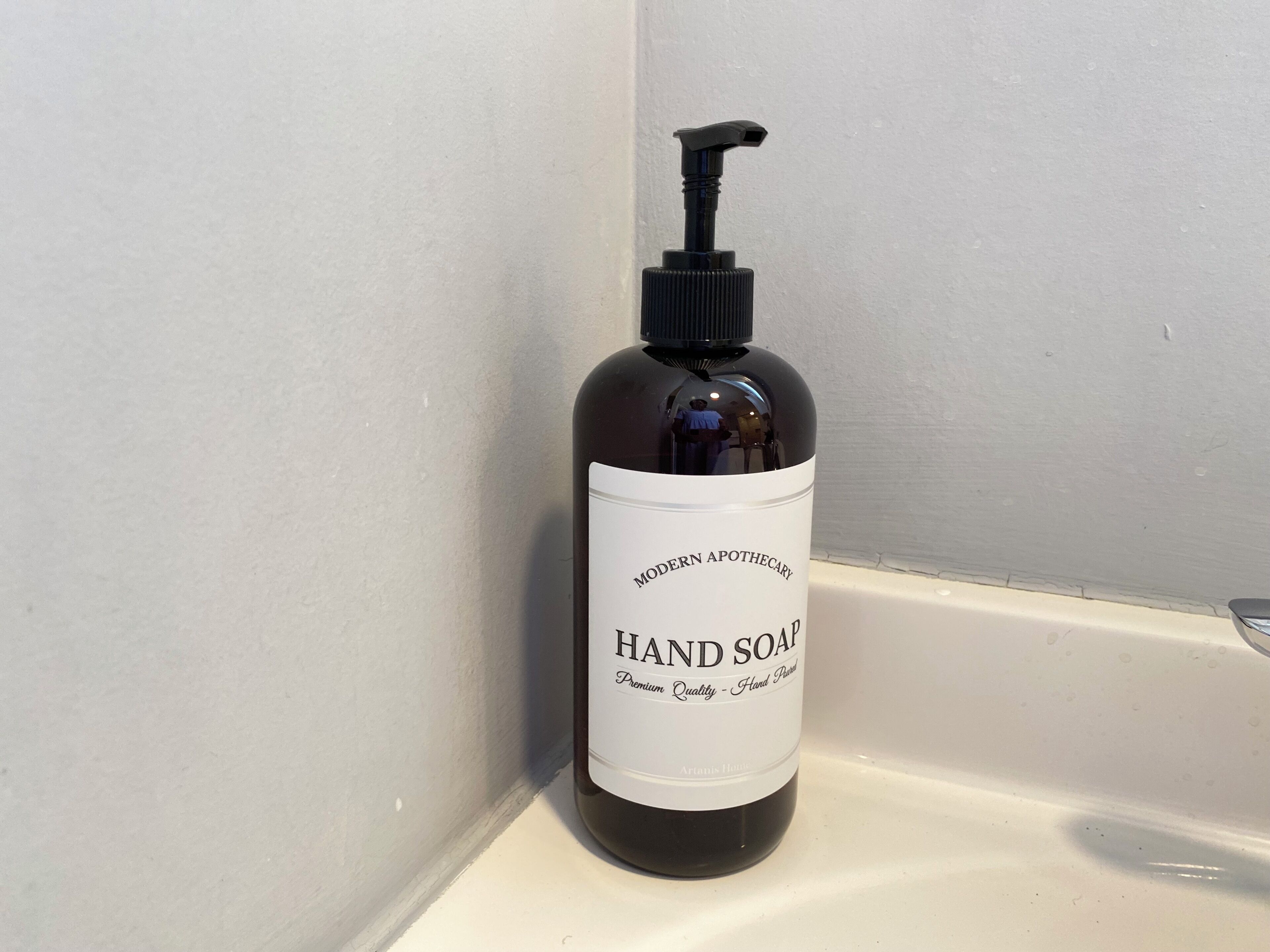 A bottle of hand soap on a white surface.