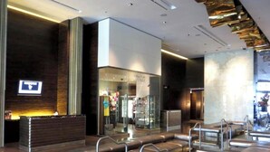 Eine moderne Lobby mit einer Rezeption, einer Sitzecke und einer Glasfassade.