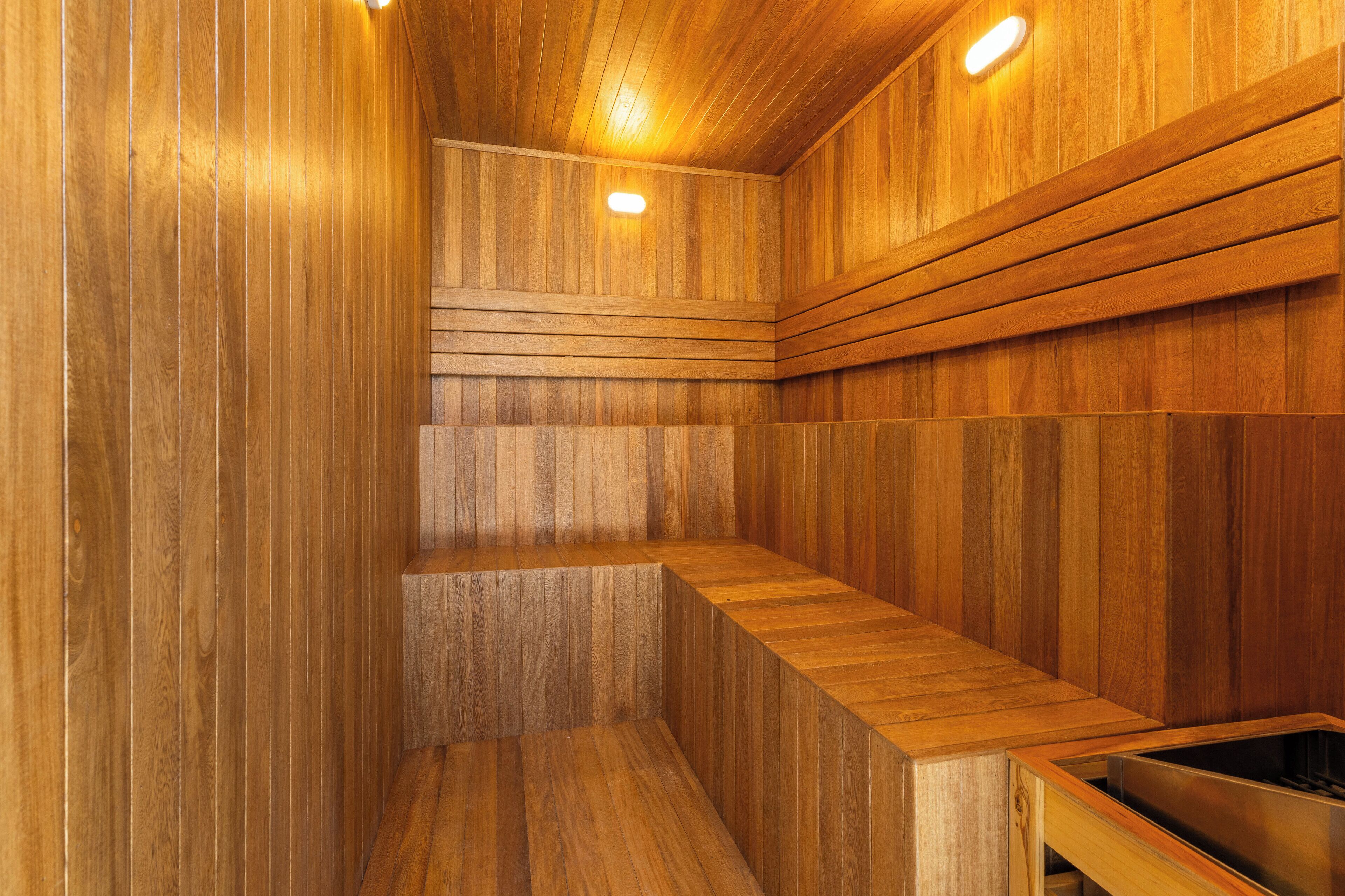 Een houten sauna met banken en een stoomruimte.