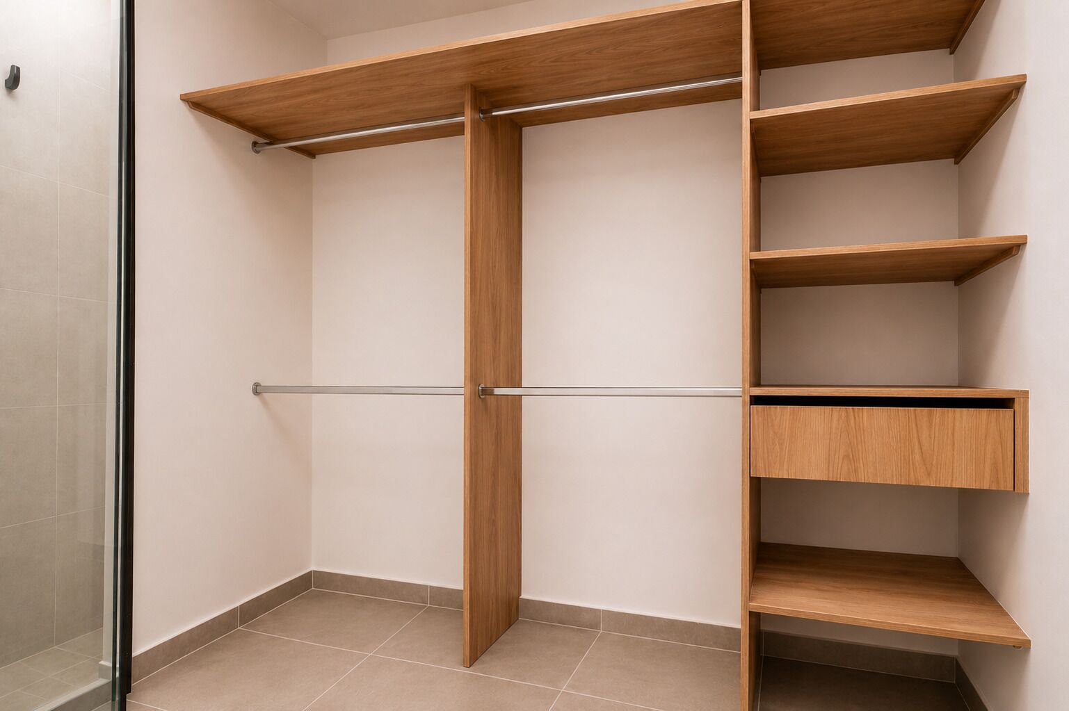 Un vestidor amplio con barra espejada, varias repisas de madera y puerta corredera.