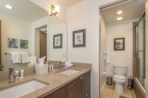 A modern bathroom with dual sinks, a large mirror, and a glass shower enclosure. - Luxury Moonlight Basin Cabin with Ski-In/Ski-Out Access, Hot Tub & Mountain Views (Big Sky)