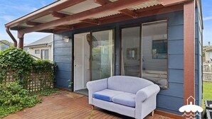 A covered porch with a white sofa and a glass door leading to a garage. - 14 Sunshine Rise Sandy Point (Sandy Point)