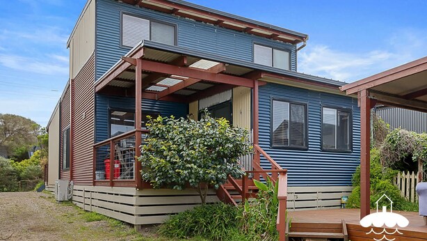 A two-story house with a wooden deck and a small garden area. - 14 Sunshine Rise Sandy Point (Sandy Point)