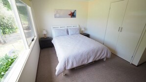 A bedroom with a bed, nightstands, a window, and a wardrobe. - 27 Beach Parade Sandy Point (Sandy Point)