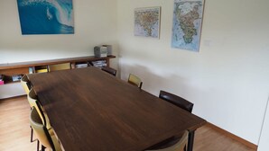 A conference room with a large wooden table, chairs, and a flat-screen TV on a shelf. - 27 Beach Parade Sandy Point (Sandy Point)