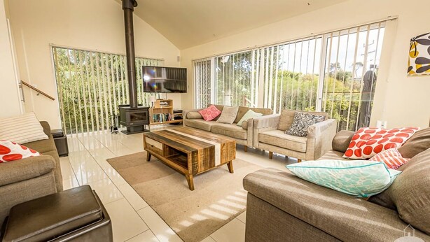 A spacious living room with a large window, a fireplace, and a flat-screen TV.