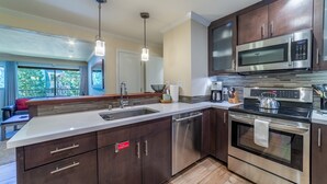 Una cocina moderna con electrodomésticos de acero inoxidable, una isla grande con un lavamanos y vistas al exterior.