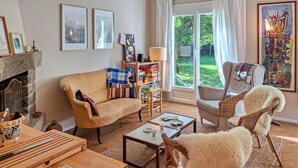 A cozy living room with a sofa, a chair, a coffee table, and a fireplace. - Amazing home in Névez with WiFi (Névez)