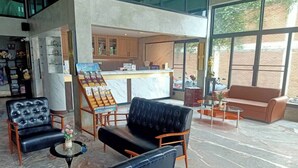 A spacious lobby with leather seating, a reception desk, and large windows offering views of the outside. - Mapeak Hotel (Chiang Mai)
