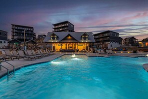 A swimming pool area with lounge chairs and a building with a restaurant in the background. - Sleeps 21 | Indoor Pool | Resort Waterpark | Views (Sevierville)