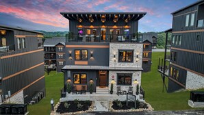 A multi-story hotel with a modern design, featuring balconies, outdoor seating, and a well-maintained lawn. - Sleeps 21 | Indoor Pool | Resort Waterpark | Views (Sevierville)