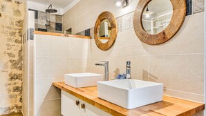 A bathroom with two white sinks, wooden countertops, and a mirror with a wooden frame.