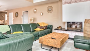 Un salon moderne avec un canapé en cuir vert, une table basse en bois et un téléviseur à écran plat.