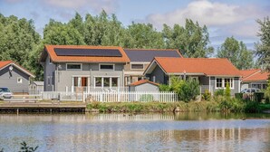 A lakeside residential area with houses featuring red-tiled roofs and solar panels. - Lovely home in BOURBOURG with WiFi (BOURBOURG)