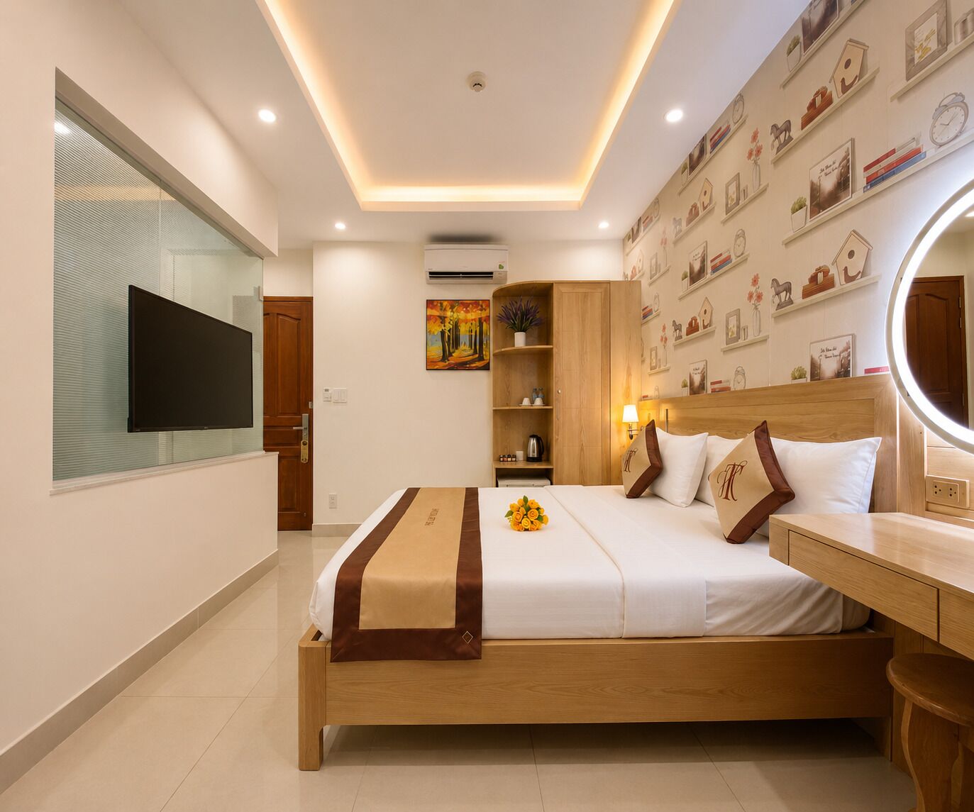 A hotel room with a bed, bedside table, mirror, wall-mounted TV, and a painting.