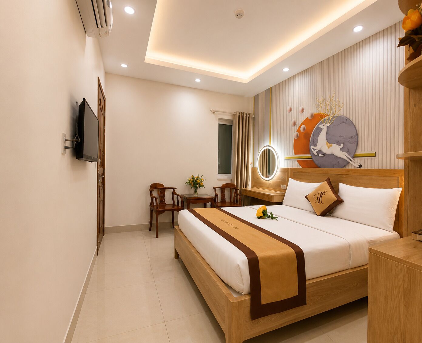 Ein Hotelzimmer mit Bett, Nachttisch, Spiegel und kleinem Schreibtisch mit Stühlen.