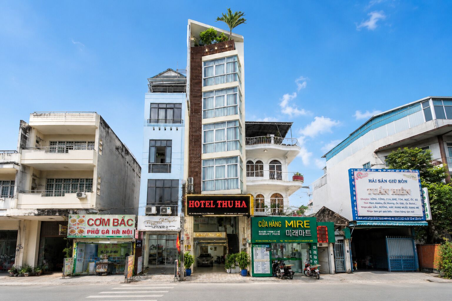 A multi-story building with a prominent hotel sign, a restaurant, and a signboard for a hotel.