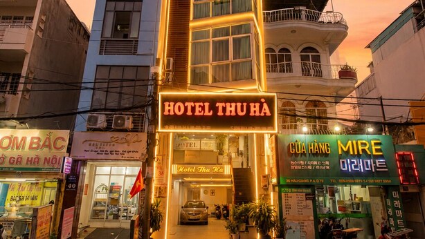 A hotel with a modern facade, a prominent entrance, and a sign indicating it is 'HOTEL THU HÀ'. - Thu Ha Airport Hotel (Ho Chi Minh City)