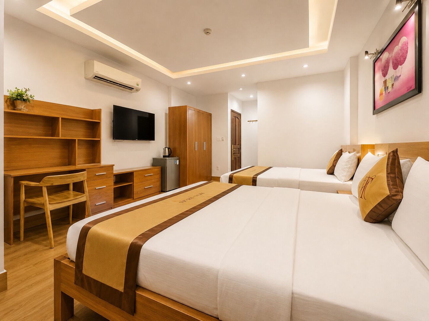 Une chambre d’hôtel comprenant un lit, un bureau, une télévision et une armoire.
