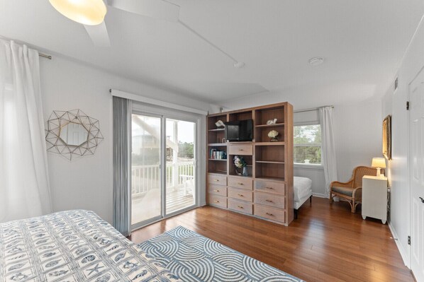 A bedroom with a bed, a wardrobe, a TV, and a chair. - Fort Morgan Beach House | Sleeps 15 | Heated Pool Coming `27 (Gulf Shores)