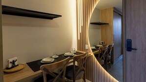Un comedor moderno con una mesa larga, sillas y un espejo que refleja la habitación.