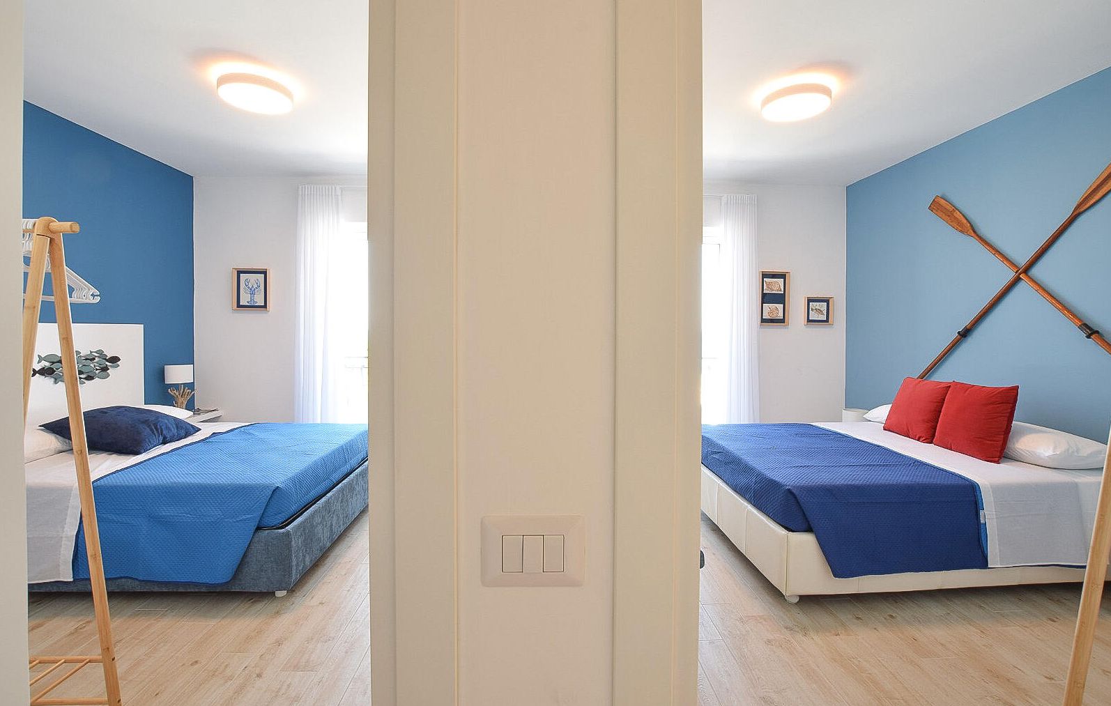 Ein Zimmer mit zwei Betten, einer Holzleiter und einem an der Wand befestigten Paddleboard.