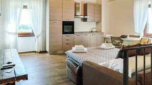 A modern hotel room with a bed, a desk, a kitchenette, and a bathroom. - Stunning apartment in Lubriano with sauna (Lubriano)