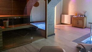 A modern spa room with a glass partition, a wooden bench, a small table with cups, and a cabinet with toiletries. - Stunning apartment in Lubriano with sauna (Lubriano)