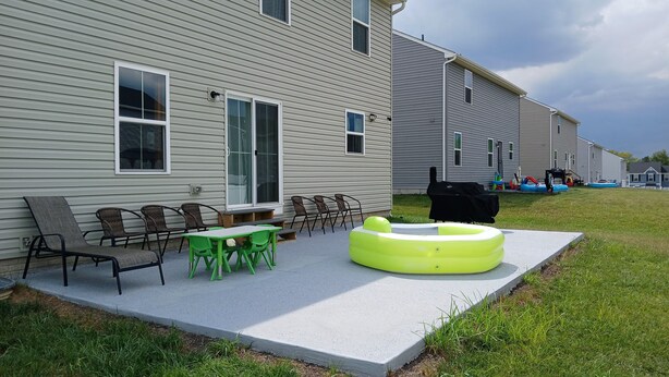 A patio with outdoor furniture, a pool, and a barbecue grill.
