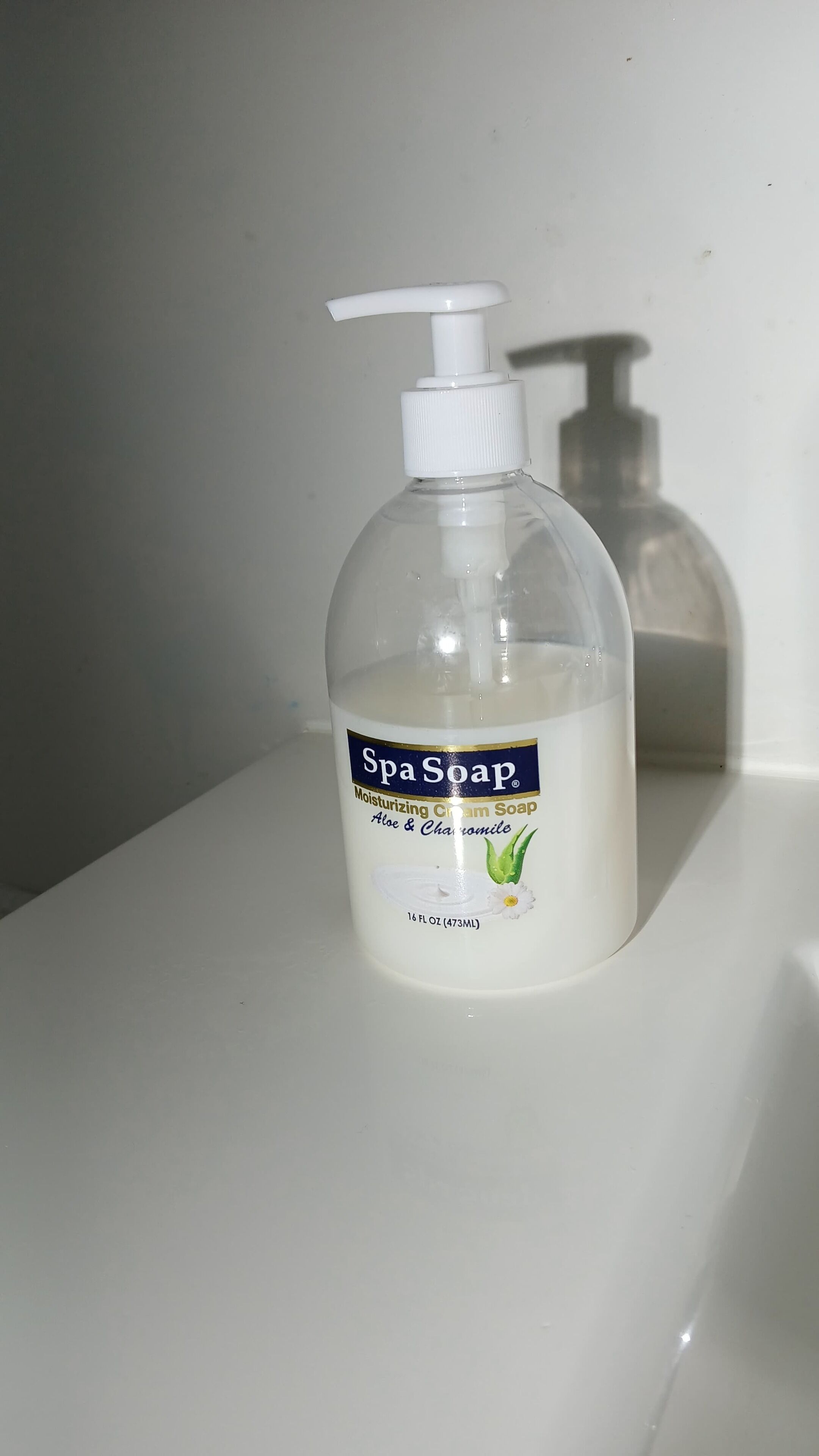 Una botella de jabón de spa sobre una superficie blanca.