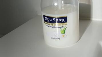 Una botella de jabón de spa sobre una superficie blanca.