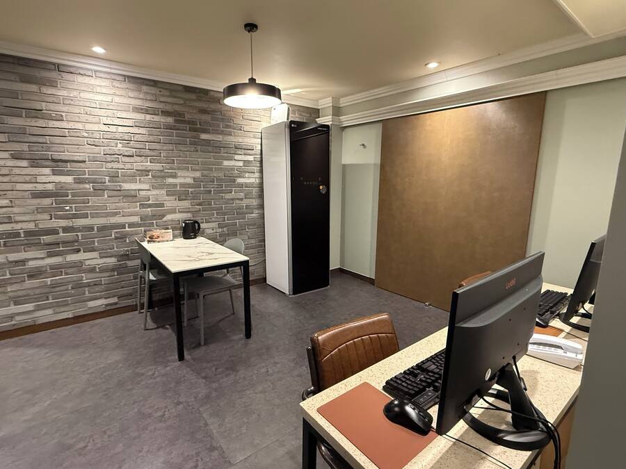 Un espacio de oficina moderno con pared de ladrillo, un escritorio con computadora y una silla.