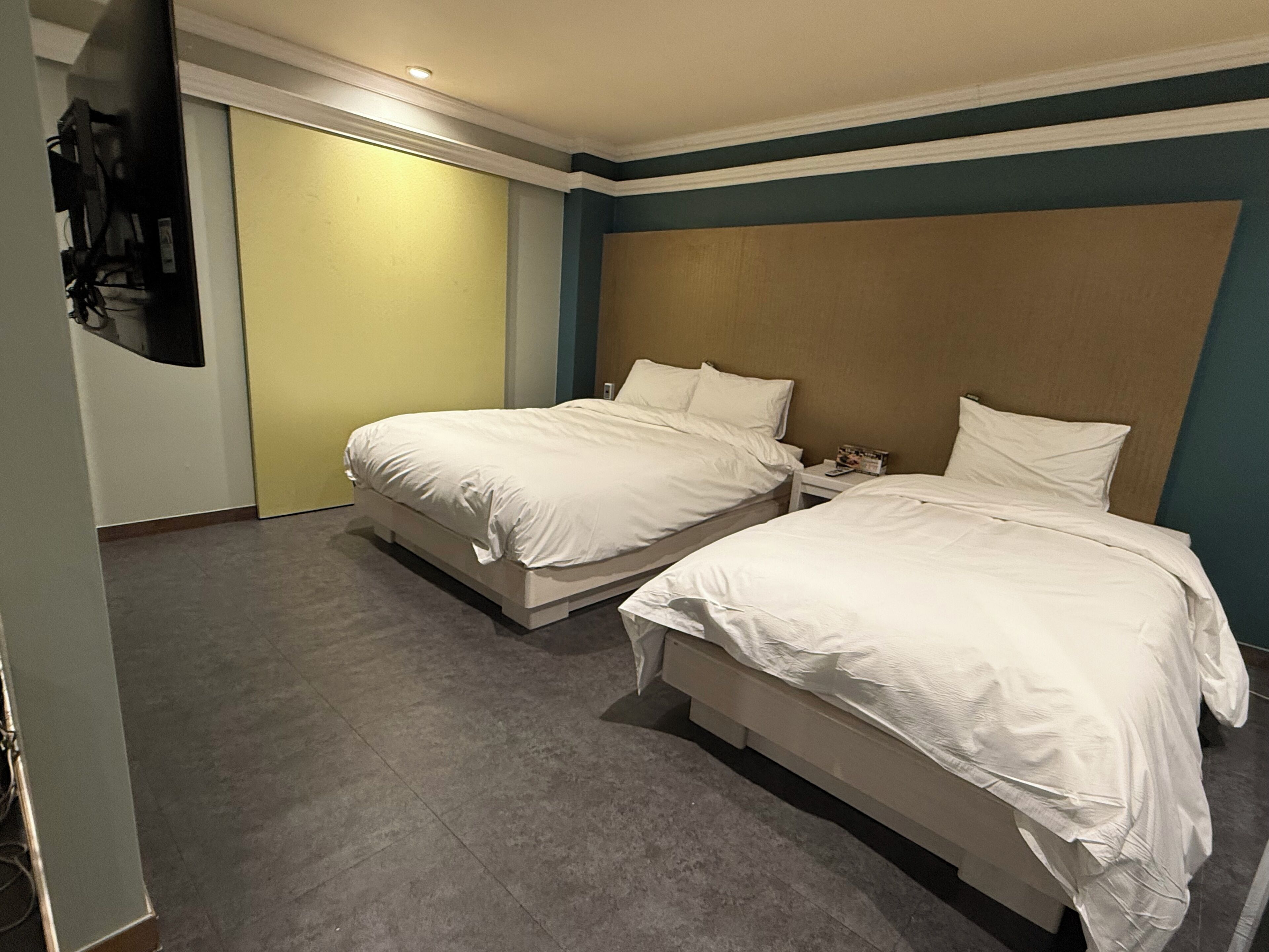 Een hotelkamer met twee bedden, een kast en een spiegel.
