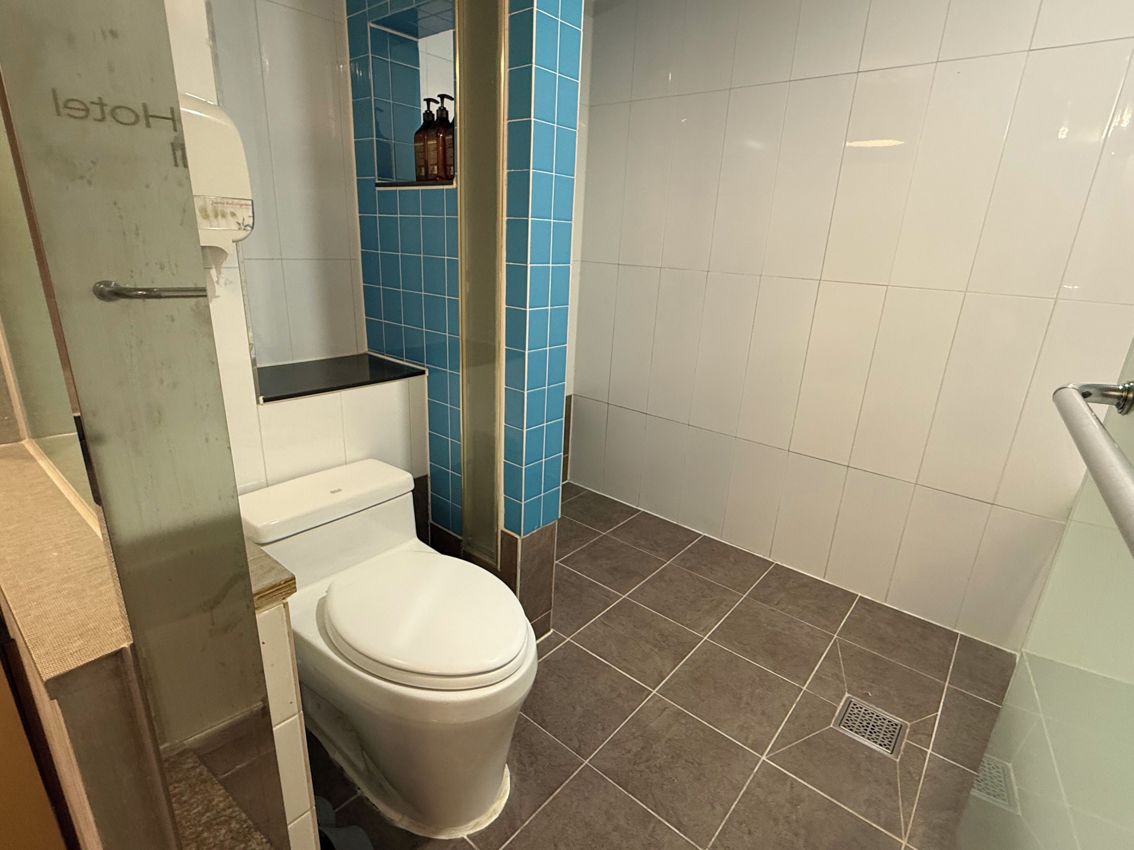 A bathroom with a toilet, a shower, and a sink.