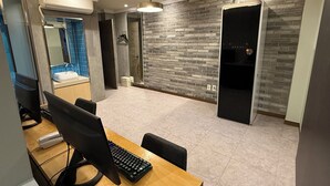 A modern office space with a wooden desk, black computer, and a large window.